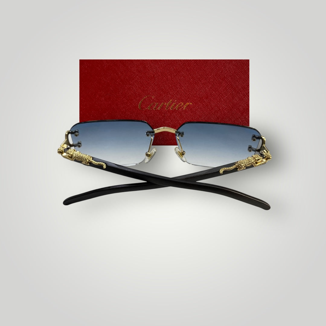 Luxury Cartier eyewear laid flat showing gradient blue lenses and intricate metal craftsmanship on rimless frame