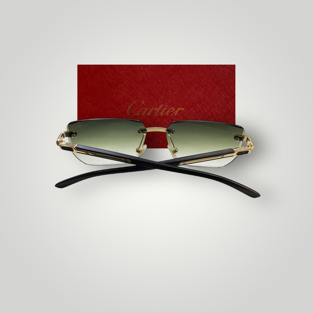 Stylish rimless Cartier sunglasses resting on a reflective surface highlighting green tinted lenses