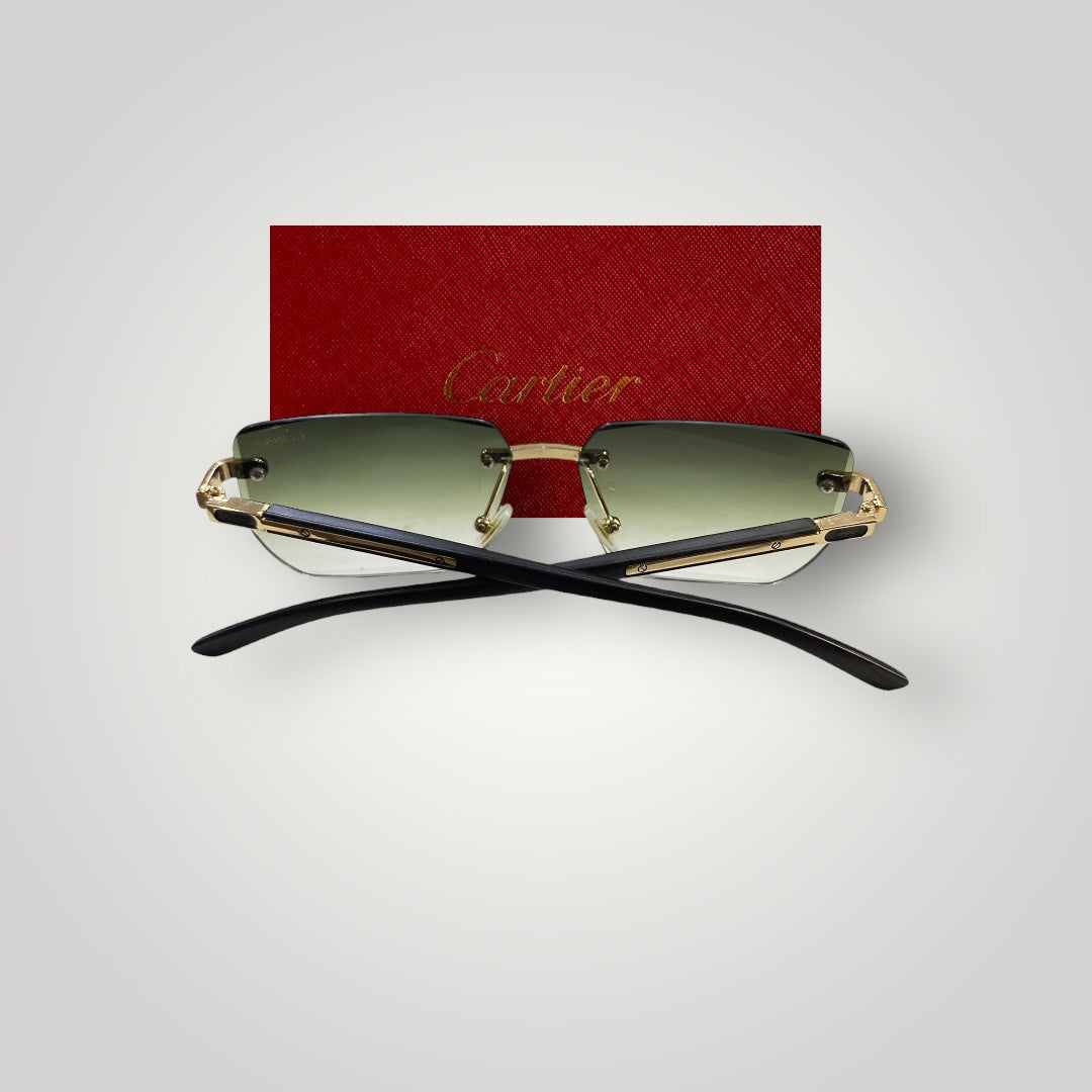 Stylish rimless Cartier sunglasses resting on a reflective surface highlighting green tinted lenses