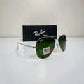 Ray-Ban Aviator sunglasses with silver frame and green lenses angled sideways on white surface with black Ray-Ban Tech branded box behind