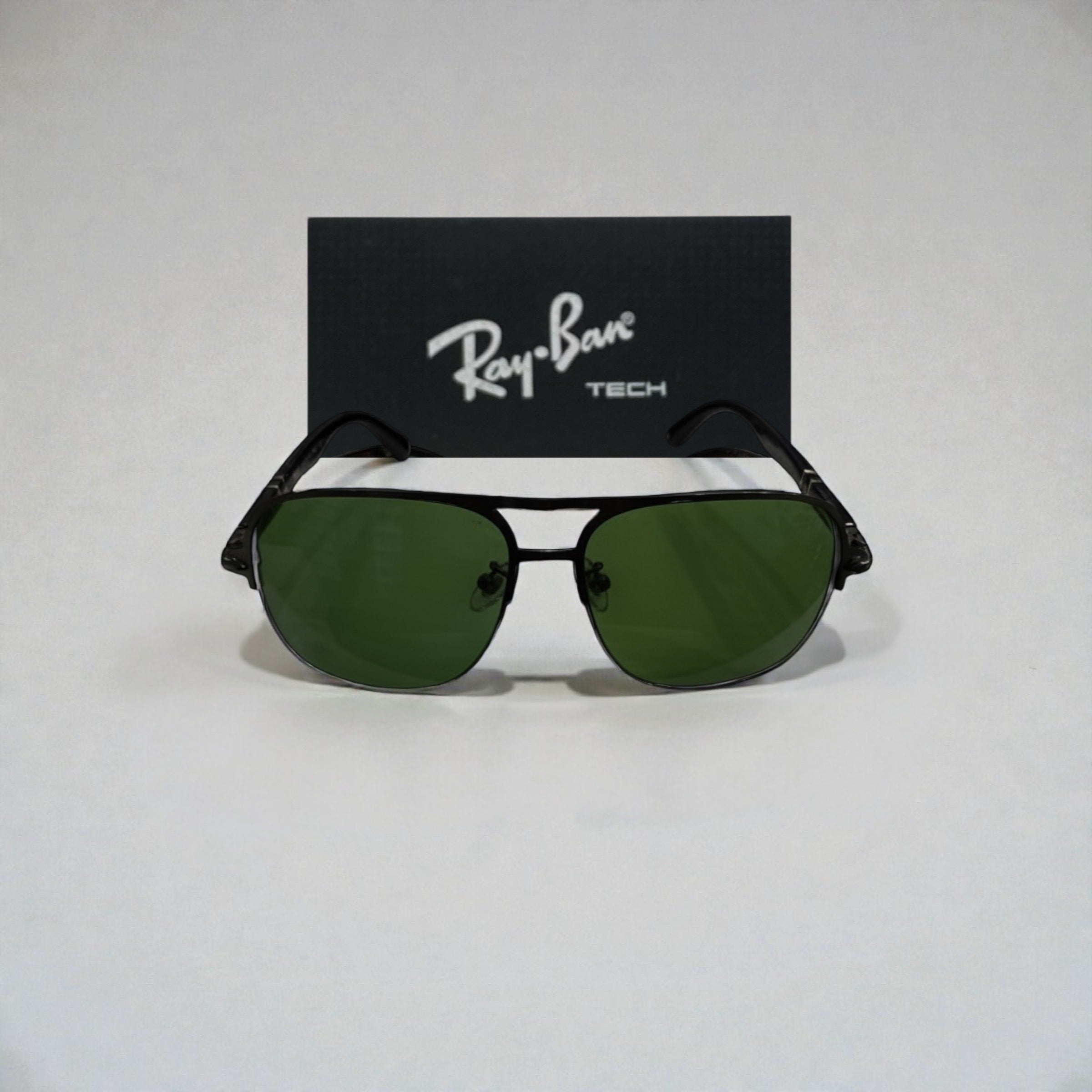 Front view of black metal Ray-Ban Tech aviator sunglasses with green lenses and Ray-Ban logo box behind