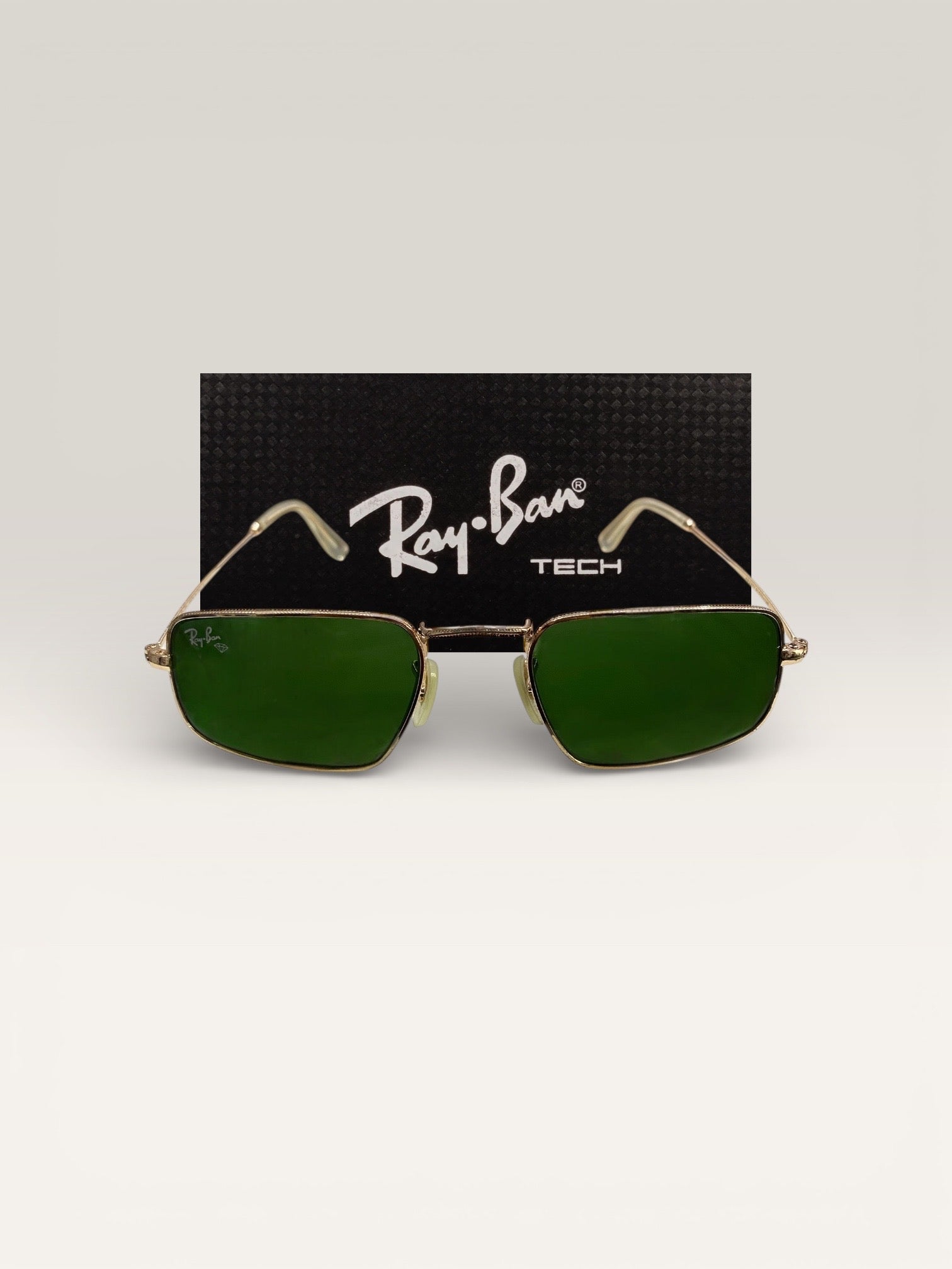 Ray-Ban Tech sunglasses with rectangular green lenses and gold metal frame front view with black Ray-Ban TECH branded background
