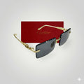 Side angle view of Cartier sunglasses with rectangular dark lenses and gold textured frames displayed in front of a red Cartier box