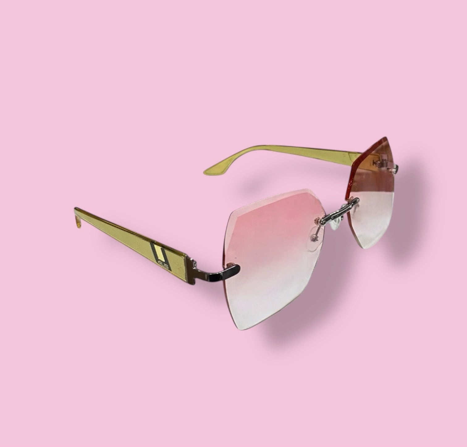 Side angle of Beenai Original 3002 women sunglasses showing rimless pink gradient lenses and gold arms on pink background