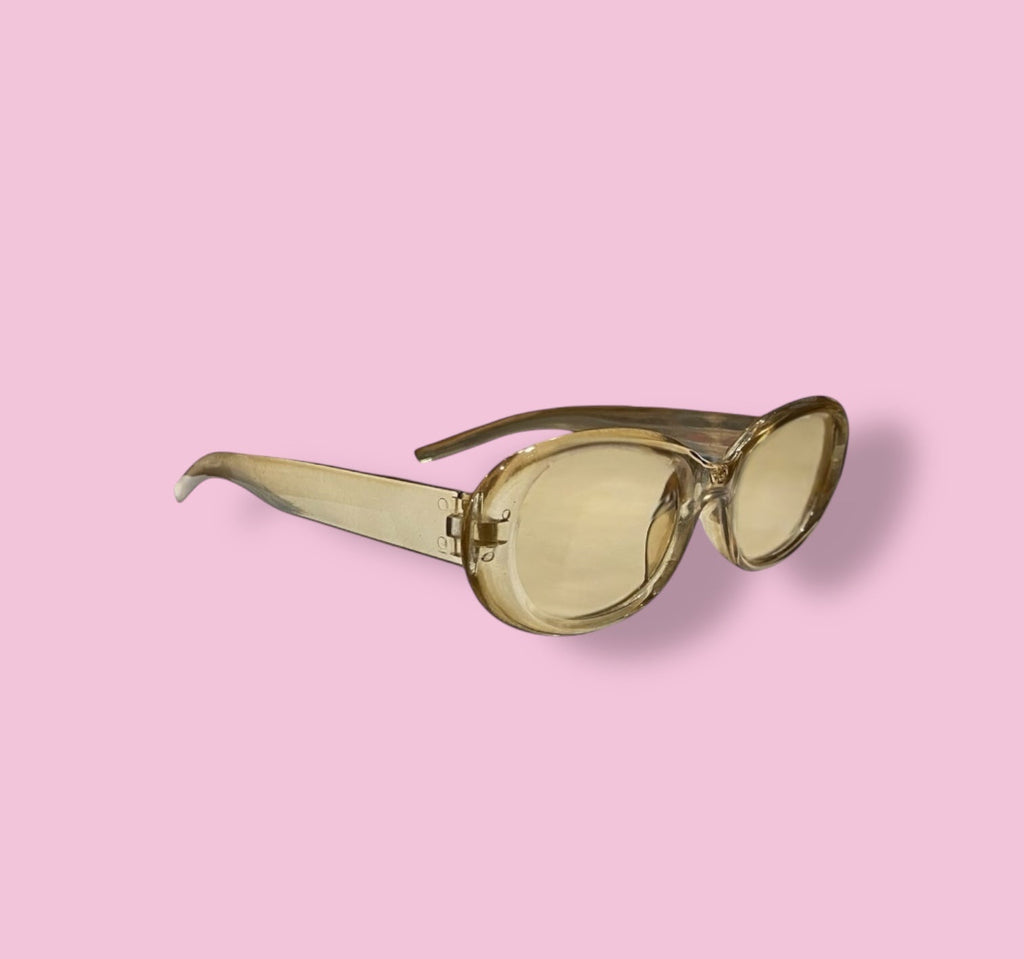 Angled side view of Beenai Original 3004 sunglasses showing the translucent amber frame and slightly curved temples on pink background